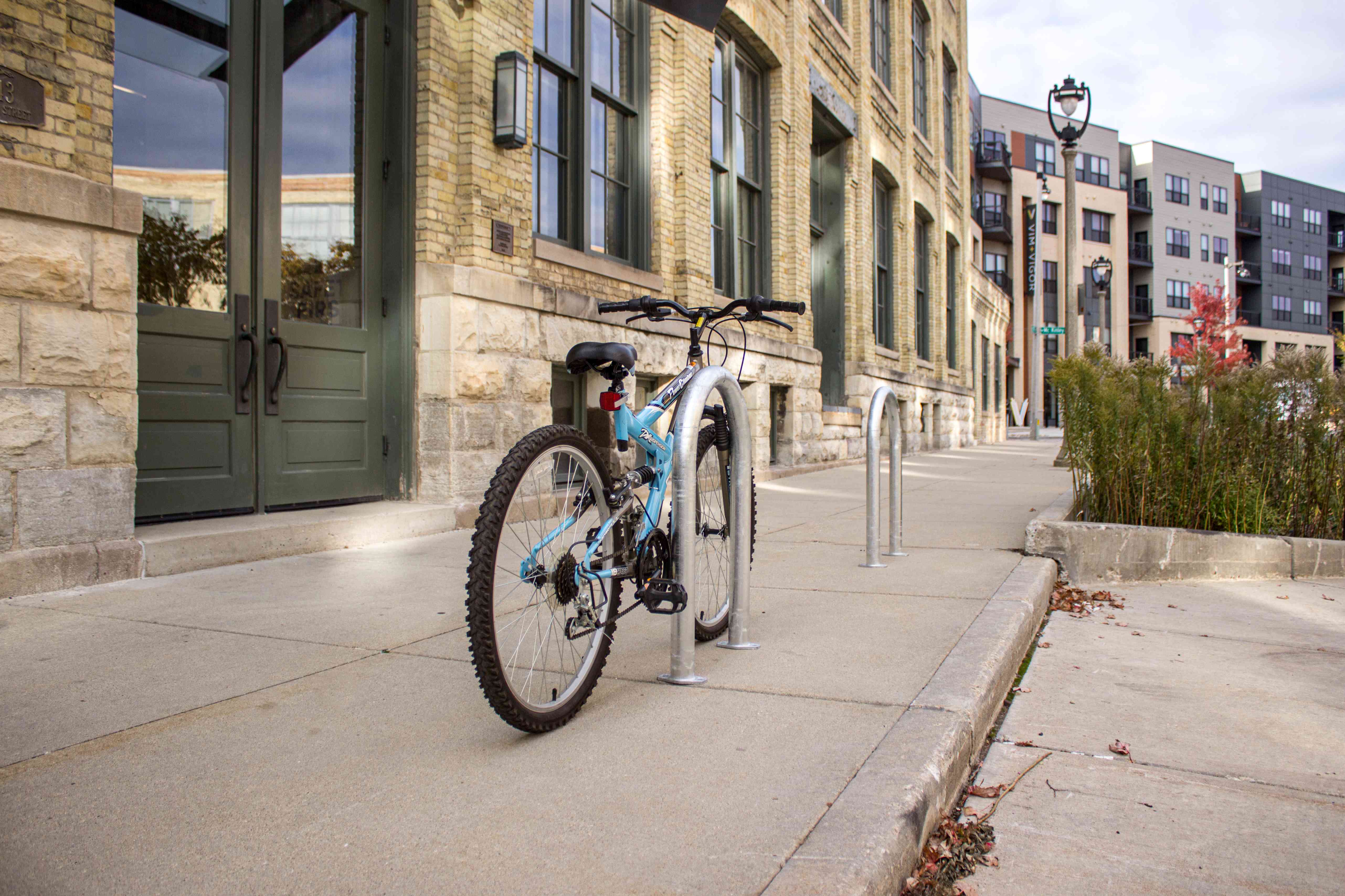 A parked bicycle on a bike rack, highlighting its design and position in an outdoor setting.