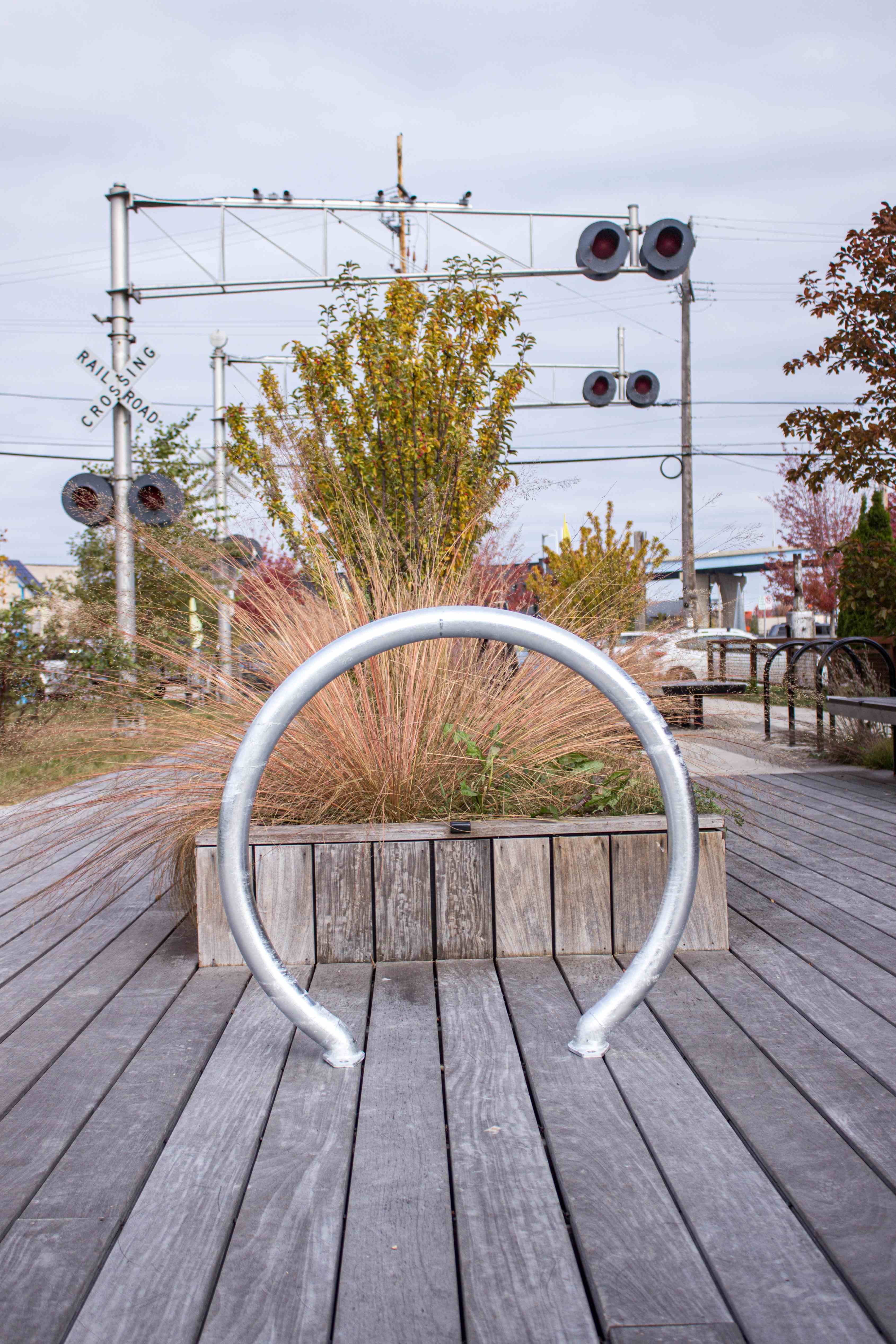 A circular bike rack mounted on a wooden walkway in a scenic outdoor setting.