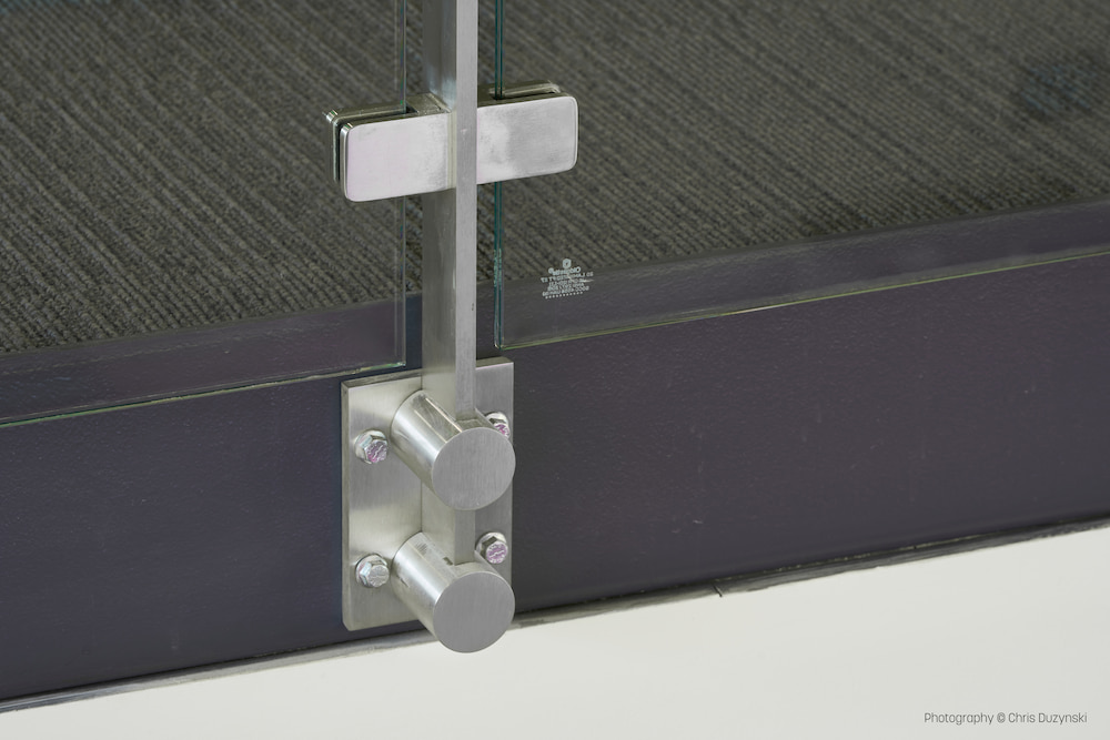 Close-up of a fascia railing mount with modern carpeted surface. The design is minimalistic and industrial in style.